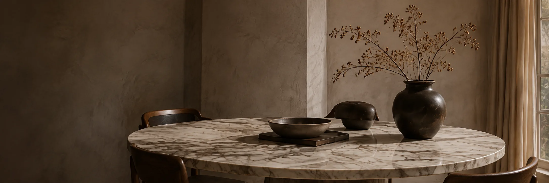 Round marble dining table styled with bronze vessels